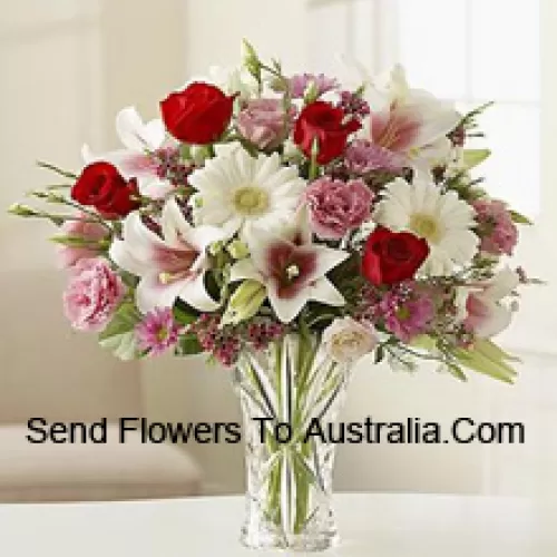 Roses rouges, œillets roses, gerberas blancs et lys blancs avec d'autres fleurs assorties dans un vase en verre